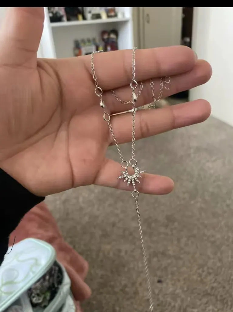 Customer holding the open silver Veloura Sun Y-Necklace