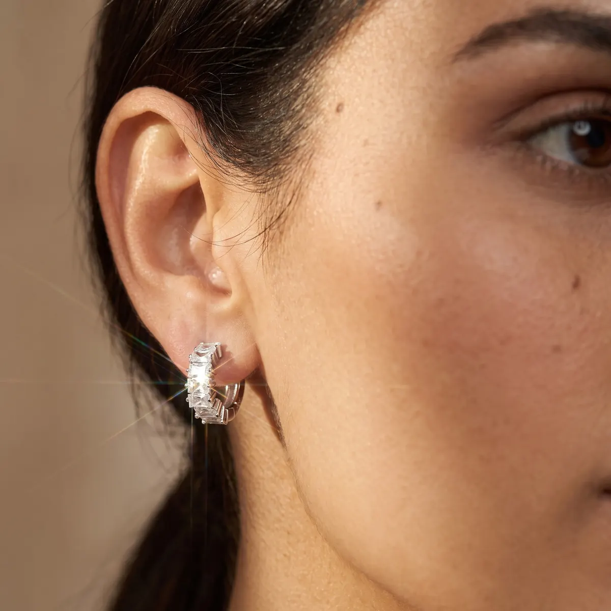 Close-up detail of a Veloura sterling silver hoop earring with white zirconia